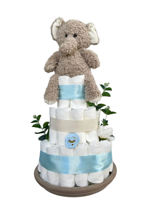 Handgjord blöjtårta med beige plyschig elefant och napp, dekorerad med ljusblått satinband
