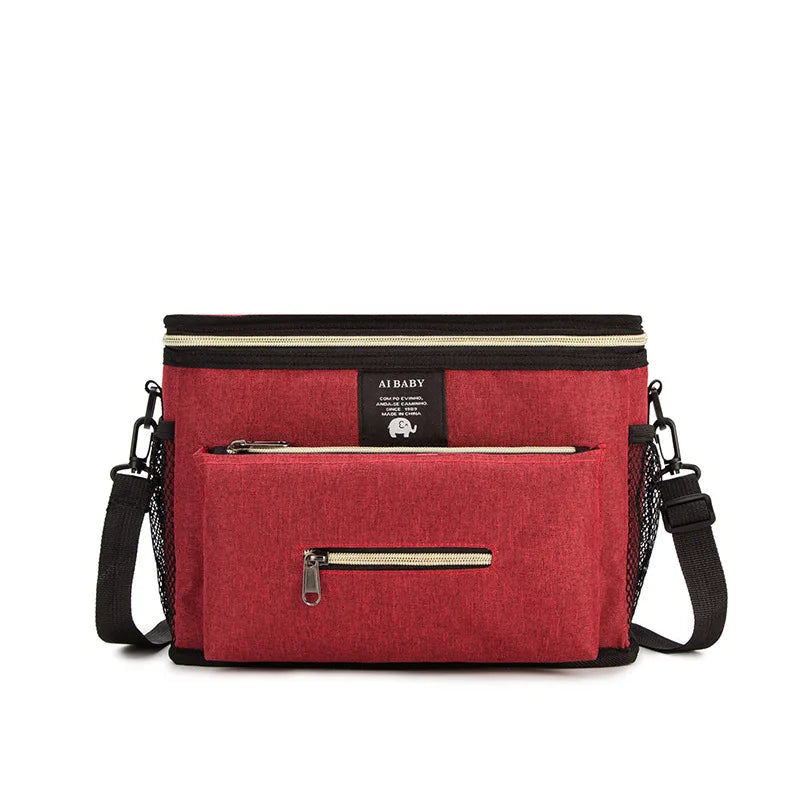 Röd vattentålig skötväska med flera fickor och bäralternativ