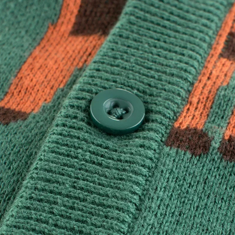 Detaljerad närbild på knapparna på en barnkofta i grön färg, visar den fina finishen och den slitstarka konstruktionen.