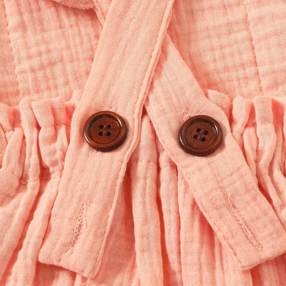 Baksida med knappar närbild på rosa ärmlös romper för nyfödda tjejer med matchande hårband