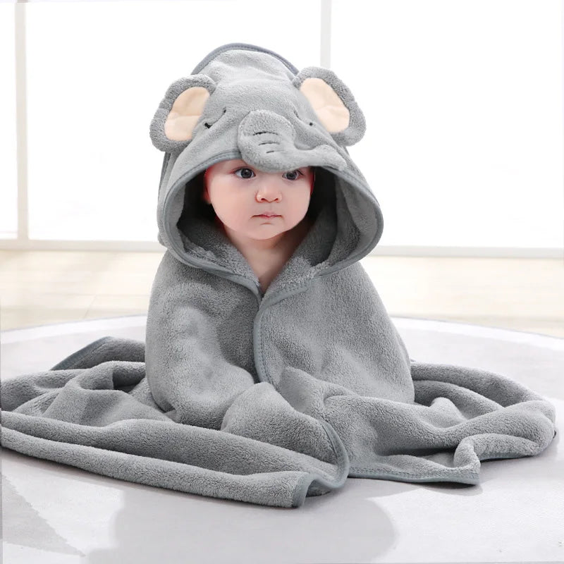 Barn sitter och är insvept i Grå Elefant Hooded Babybadhandduk med huvan på.
