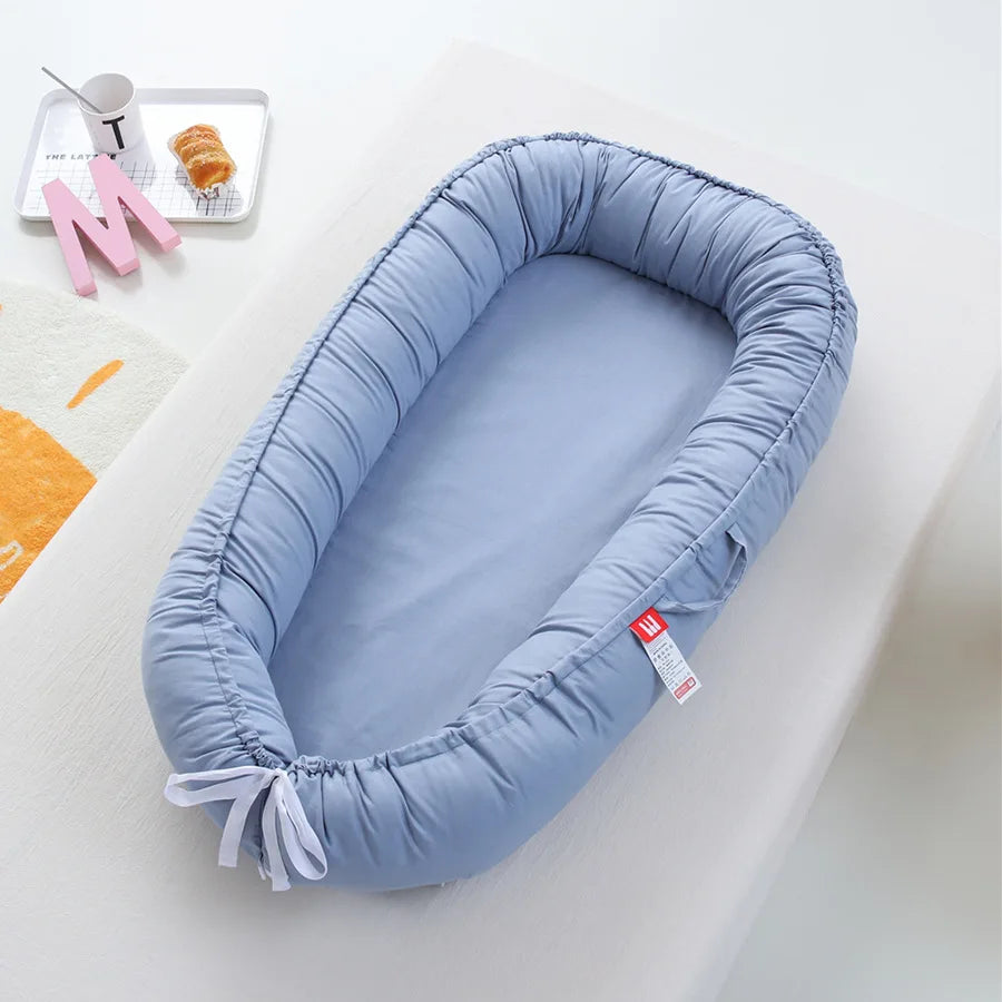 En mörkblå myspöl mot en vit bakgrund, babynest som är mjuk och stilren.